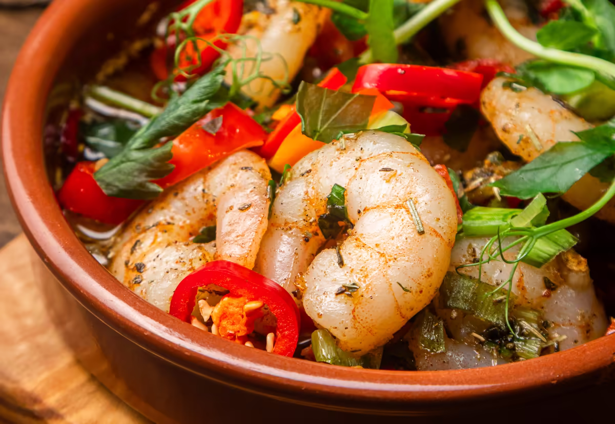 Sizzling sherry prawns with red peppers and chilli in a terracotta dish